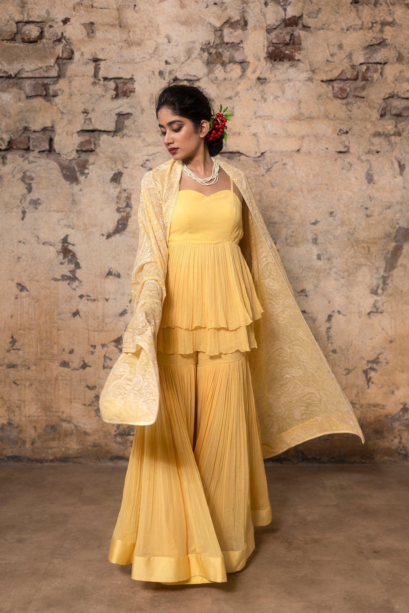 Yellow pleated sharara paired with peplum top and embroidered dupatta
